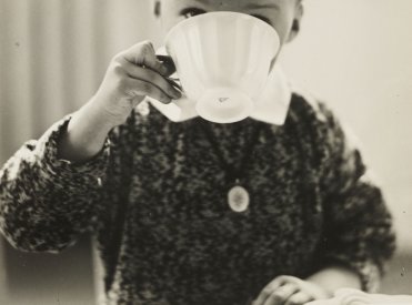 Kleiner Junge trinkt aus großer weißer Teetasse