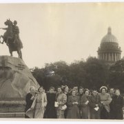 Die Schwarzweissfotografie von 1953 zeigt Helene Bosserts Reisegruppe in St. Petersburg. Die Gruppe von Frauen in Mänteln steht neben dem ehernen Reiter, dem Denkmal für Zar Peter den Ersten; im Hintergrund sieht man Bäume und einen Kuppelbau.