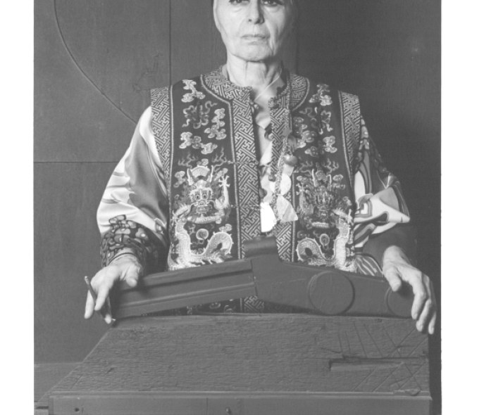 Black-and-white photo of the artist in front of a sculpture shaped like a stapler