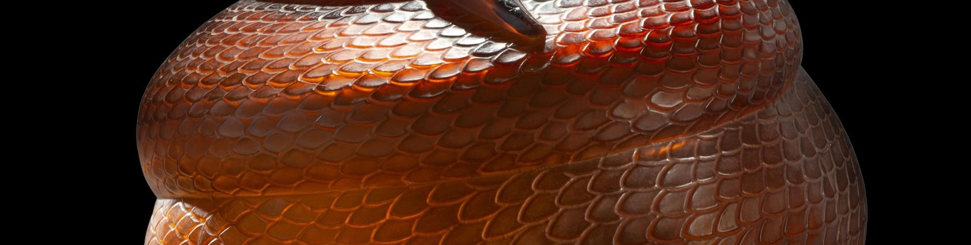 Vase Serpent en verre rouge - le gros serpent dont on voit les écailles est enroulé autour d'un vase rond et a la gueule ouverte au niveau du col du vase