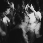 Black and white photo of people dancing. The picture is out of focus in exception of the woman in the center of the photo.