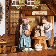 Schnitzerszene und Trachtenfrau in einer Kuckucksuhr