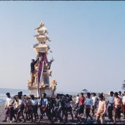 Eine Beerdigung auf Bali mit einem getragenen Altar, der in die Höhe ragt und wie ein kleiner Tempel aussieht.