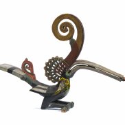 Figure d'oiseau dans les tons or et rouge avec un très long bec et une longue corne incurvée.