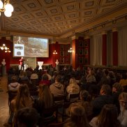 Vortrag in der Aula mit Präsentation auf der Leinwand (c) Jeton Shali