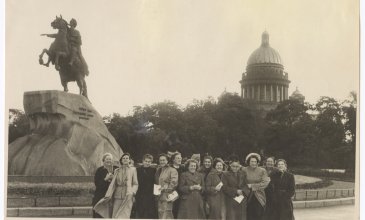 Die Schwarzweissfotografie von 1953 zeigt Helene Bosserts Reisegruppe in St. Petersburg. Die Gruppe von Frauen in Mänteln steht neben dem ehernen Reiter, dem Denkmal für Zar Peter den Ersten; im Hintergrund sieht man Bäume und einen Kuppelbau.