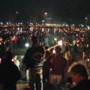 Man sieht eine Menschenkette im Dunklen. Die Menschen halten Lichter in den Händen.