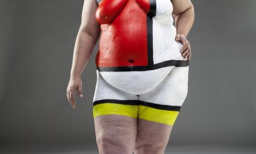 Fotografie einer nackten Frau bemalt mit verschiedenen Farben im Stile Mondrians.