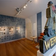 Blick auf Wandtexte und Exponate sowie ein Schild der Werola im Jüdischen Dokumentationsraum