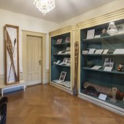 Ausstellungsansicht des aktuellen Schaufenster Archivs mit historischen Fotos, Kartenmaterial und einem Zeremonial-Paddel