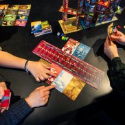 Verschiedene Kartenspiele auf einem dunklen Tisch.