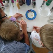 Familiensonntag Vater mit zwei Söhnen beim Bemalen einer Figur