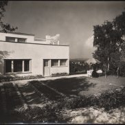 Schwarz-weiß-Fotografie eines modernen Hauses mit Flachdach und Garten