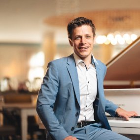 Der Pianist Benedikt Weigmann sitzt vor einem Piano. 
