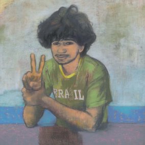 Junge zeigt Peace-Zeichen und trägt ein grünes T-Shirt und hat schwarze Locken