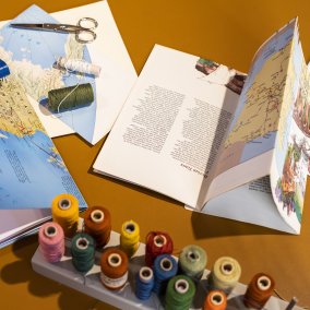 Blick auf den Basteltisch mit Weltkarte, Faden und weiterem Bastelmaterial