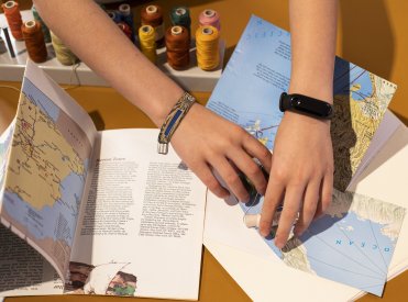 Kinderhände basteln ein mit einer Landkarte ein Ferientagebuch