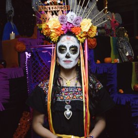 Eine Catrina Eine Catrina – eine totenkopf-geschminkte Frau mit farbigen Blumenhaarschmuck