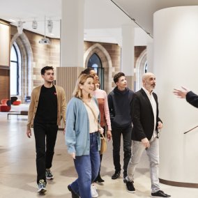 Mehrere Menschen gehen in die Richtung, in die ein Mann zeigt.
