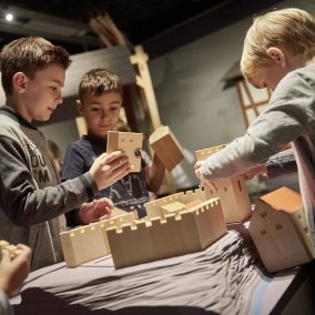 Kinder bauen ein Schloss aus Holzbausteinen. Landesmuseum Württemberg, Stuttgart; Foto: Martin Sigmund