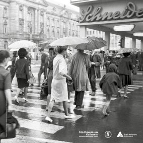 Plakat mit schwarz-weiß Fotografie von Menschen, die über einen Zebrastreifen gehen.