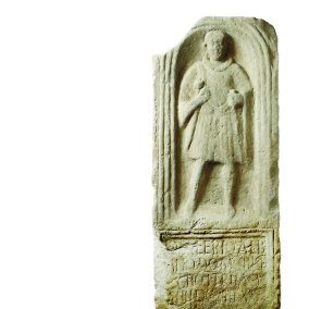 eine Steinplatte mit einem Relief von einem Mann und teilweise leserlicher Schrift