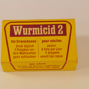 Altes Anti-Wurmmittel aus dem 20. Jahrhundert Altes Anti-Wurmmittel aus dem 20. Jahrhundert, gelbe Kartonschachtel mit roter Aufschrift: "Wurmicid 2"