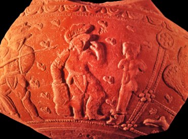 Gladiateurs se préparant au combat. L'un d'eux se recueille devant un terme. On aperçoit à droite l'aigle de Taranis et le lièvre de Rigani , divinités gauloises.