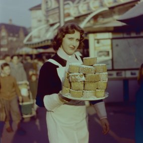 Frau mit einem Teller «Rosekiechli» an der Basler Herbstmesse, 1950er-Jahre. Foto Jeck Basel. StABS, BSL 1060c 3/8/377