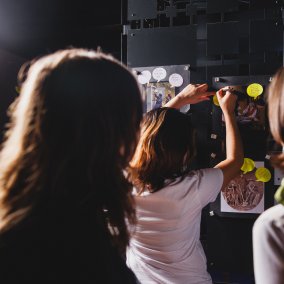 Drei Personen im Museum schauen zusammen etwas an und arbeiten zusammen.