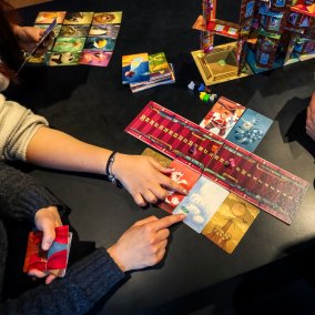 Verschiedene Kartenspiele auf einem dunklen Tisch.