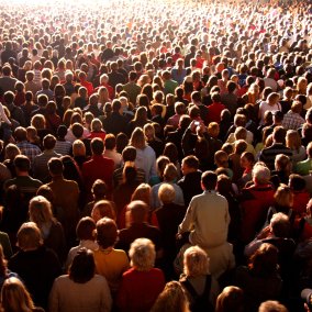 Symbolbild MASSEN – FOULES – CROWDS Menschenmasse an Konzert oder Ähnlichem. Von hinten fotografiert. Es sind keine Gesichter zu sehen.