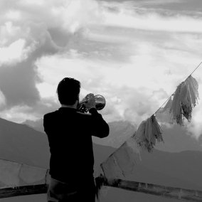 Daniel Woodtli, unter anderem Jazztrompeter, steht vor beeindruckendem Bergpanorama.