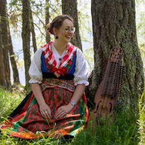 Musikerin Lorène Quinodoz sitzt in idyllischer Waldkulisse