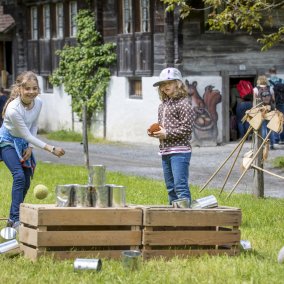 Des enfants lancent des canettes au musée suisse en plein air Ballenberg.