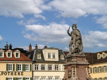 Der Ludwigsburger Markplatz mit Statue in der rechten Bildhälfte. Die Statue trägt einen Mund-Nasen-Schutz