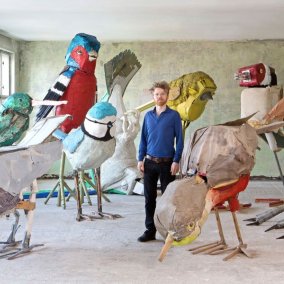 Der Künstler Matthias Garff steht in seinem Atelier zwischen seinen überlebensgroßen Vogelskulpturen