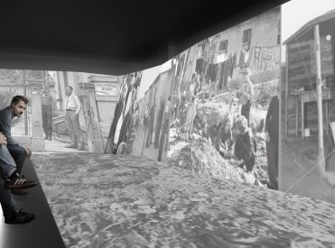 Blick in den Bunkerraum. Große Displays zeigen Kinder, die in Trümmern spielen.