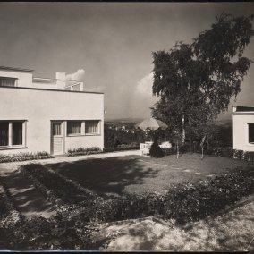 Schwarz-weiß-Fotografie eines modernen Hauses mit Flachdach und Garten