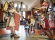 Drei Mädchen stehen in einem Ausstellungsraum im Vindonissa Museum, vor ihnen zwei römische Legionäre in Lebensgrösse.