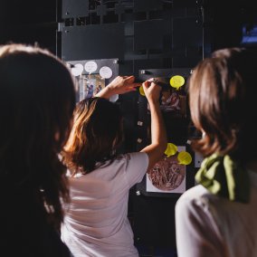 Drei Personen im Museum schauen zusammen etwas an und arbeiten zusammen.
