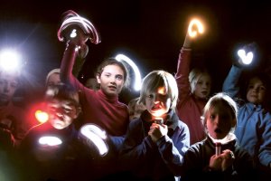 Das Bild zeigt eine Gruppe Kinder mit Taschenlampen in der Nacht. @zVg