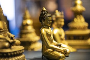 Mehrere goldene Buddhas sitzen auf einem Podest