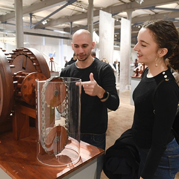 Besuchende testen das Modell eines Ketten-Ratschen-Getriebes.