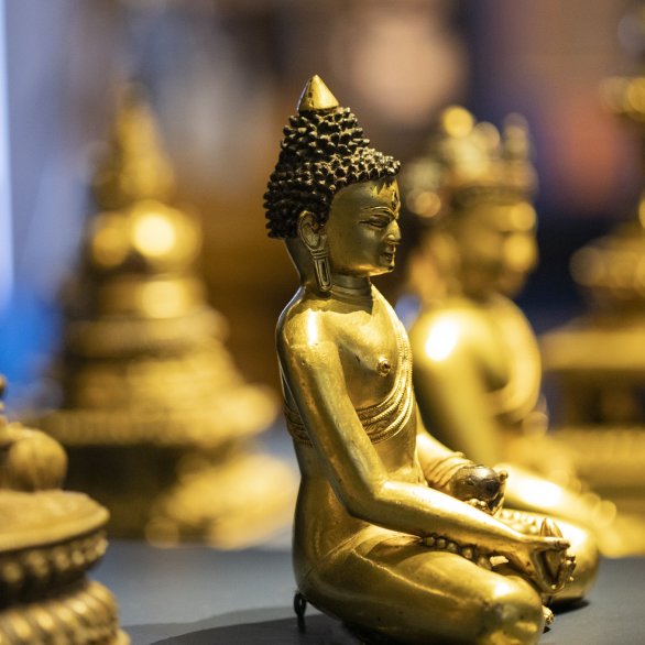 Mehrere goldene Buddhas sitzen auf einem Podest