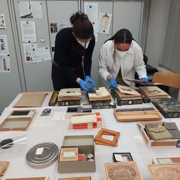 Blick hinter die Kulissen bei der Beforschung der Fotosammlung; zwei Forscherinnen begutachten Fotoalben