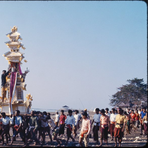 Eine Beerdigung auf Bali mit einem getragenen Altar, der in die Höhe ragt und wie ein kleiner Tempel aussieht.