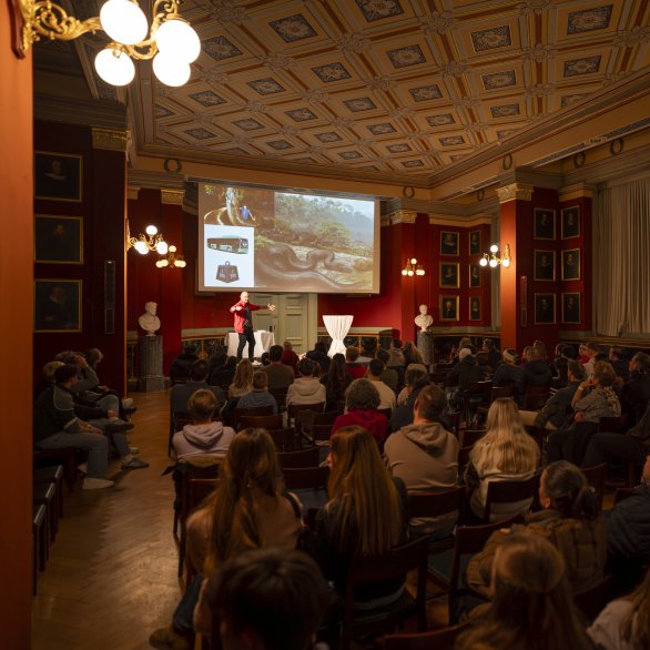 Vortrag in der Aula mit Präsentation auf der Leinwand (c) Jeton Shali
