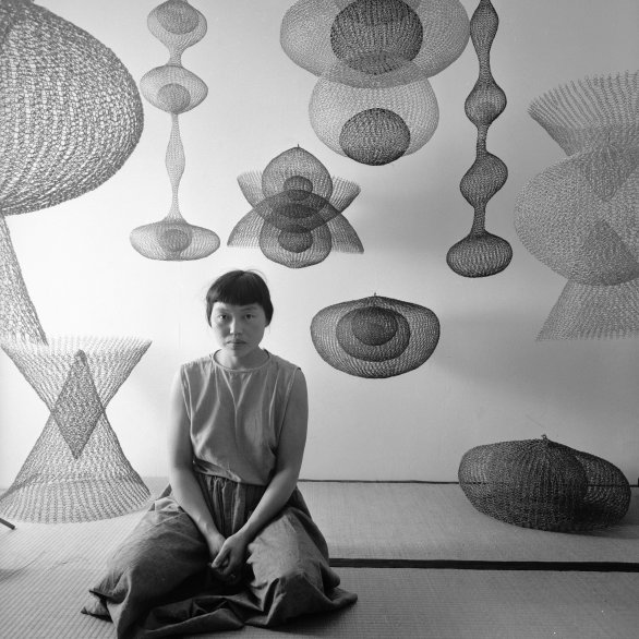 Portrait of Japanese American artist Ruth Asawa as she kneels on the floor amid several of her looped-wire sculptures, November 1954. Photo: Nat Farbman/The LIFE Picture Collection/Shutterstock Artwork © 2025 Ruth Asawa Lanier, Inc., Courtesy David Zwirner