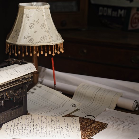 Un intérieur de maison alsacienne avec des objets de collections du musée : machines à écrire, lampe de bureau.